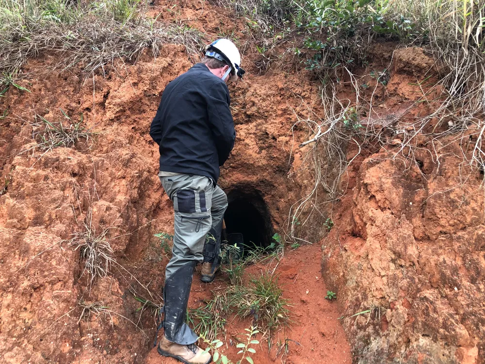 Field geologist at entrance to small artisanal excavation
