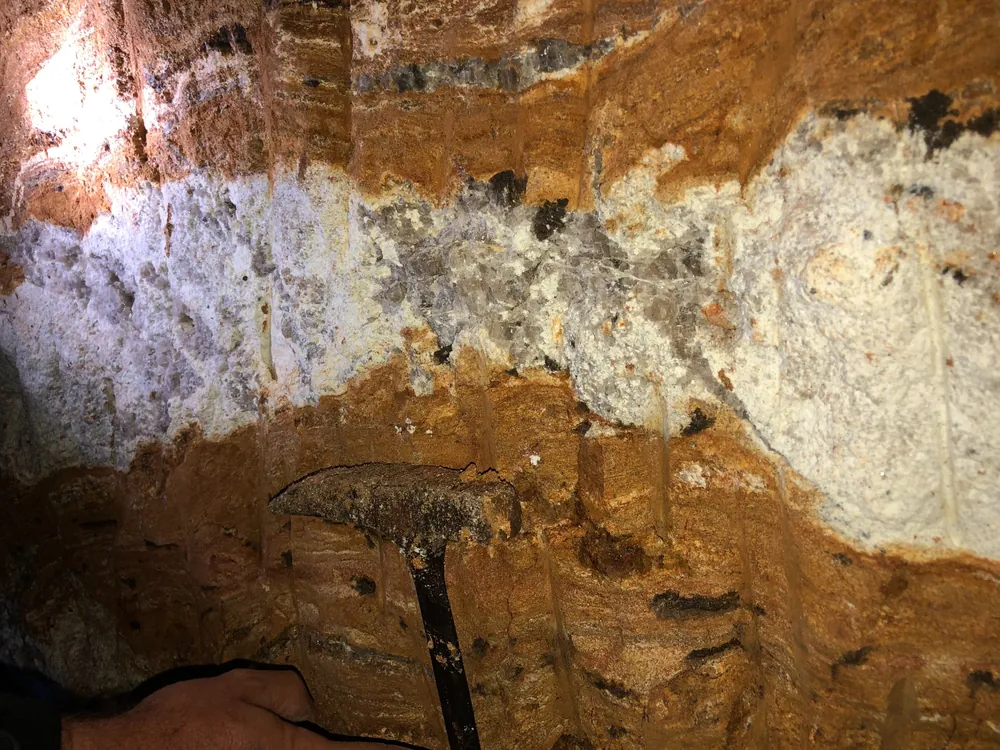 Pegmatite vein cutting schist exposed within a gallery.