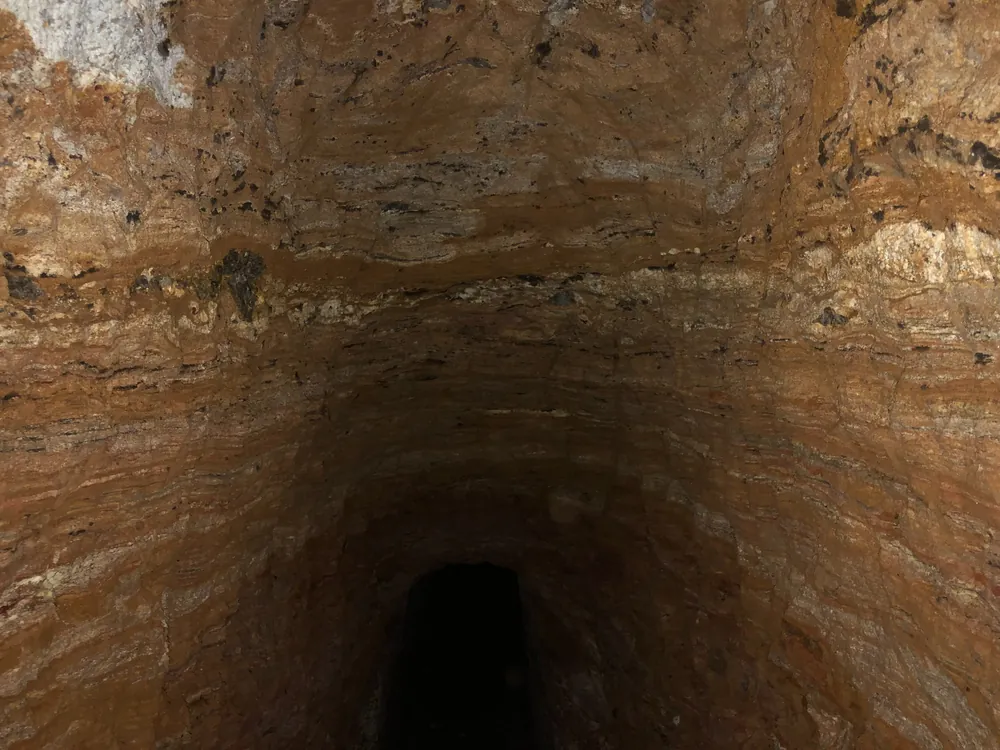 Hand-dug subsurface gallery exposing a pegmatitic zone within weathered host rock at Novo Cruzeiro.