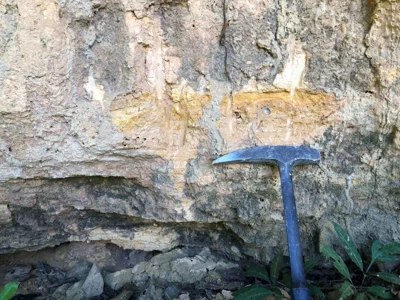 Yellow-grey saprolite with relict foliation and rock hammer scale