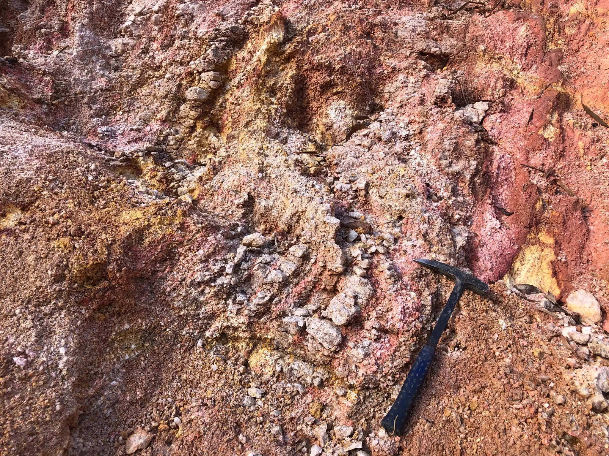 Kaolinized and iron-stained saprolite with pink to yellow banding.