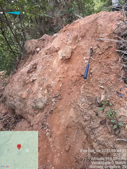Weathered hillside exposure with clay-rich saprolite and embedded coarse rock fragments at Novo Cruzeiro.