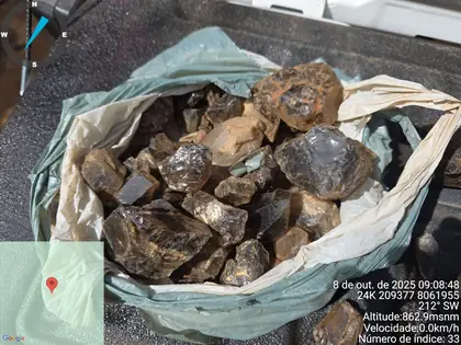 Bagged pegmatite samples with coarse biotite, quartz, and feldspar fragments.