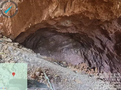 Wide artisanal tunnel through reddish-brown saprolite.