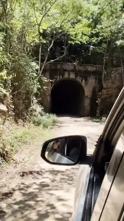 Historic tunnel entrance cut into the Novo Cruzeiro hillside — one of several man-made passages giving access to mineralized zones.